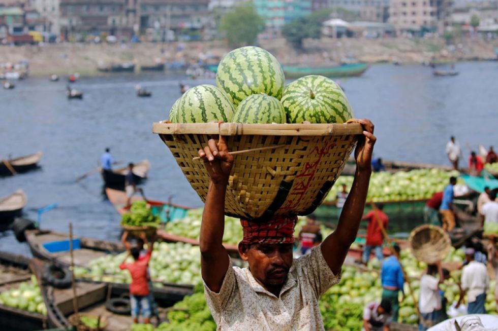 Un trabajador descarga sandías de varios barcos en el río Buriganga, en Dacca (Bangladesh). EFE/Monirul Alam
