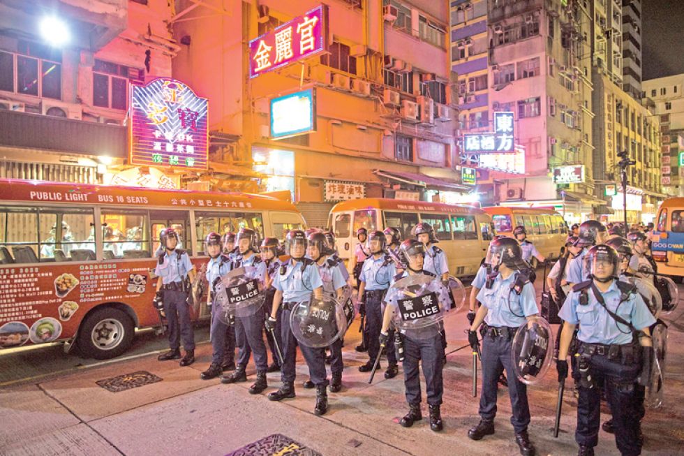 TENSIÓN. Policías hongkoneses vigilan las principales calles de esa ciudad estado ante el posible resurgimiento de las protestas.