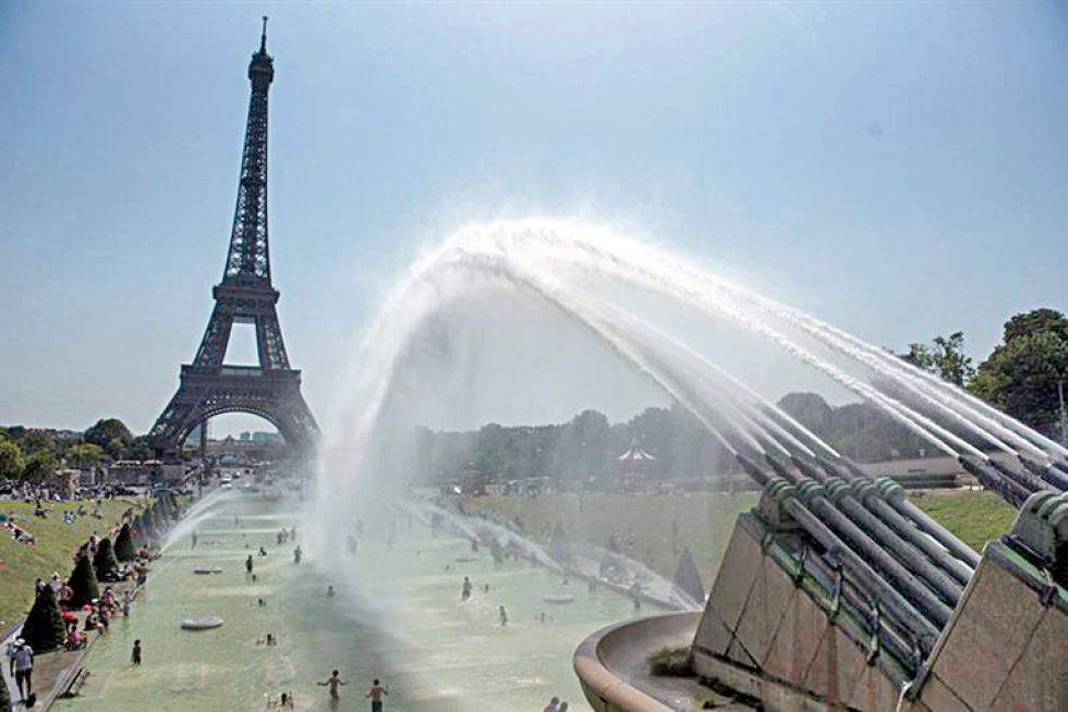 CLIMA. Varias personas se refrescan en los Jardines del Trocadero, cerca de la torre Eiffel.