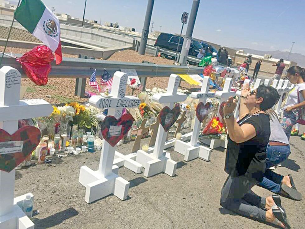 MATANZA. Una mujer reza en El Paso,Texas, ante varias cruces colocadas en recuerdo de las víctimas del tiroteo en un supermercado.