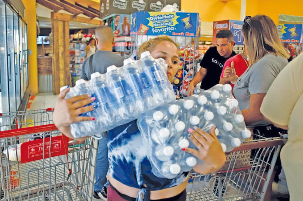 PREPARATIVOS. Ciudadanos se abastecen de elementos de primera necesidad, agua principalmente, tras declararse la emergencia por "Dorian".
