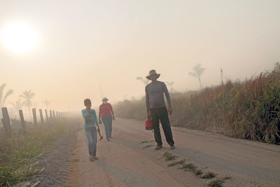 DESASTRE. Una familia de agricultores cubierta de humo debido a los incendios en la selva amazónica cerca de Porto Velho.