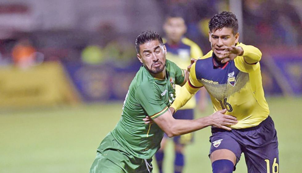 Rodrigo Ramallo (i) intenta detener a un rival ecuatoriano, en el partido amistoso disputado en Cuenca, el martes.