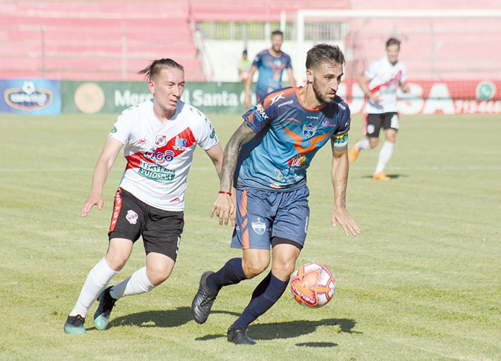 El mediocampista warneño Luciano Ursino (d) escapa con el balón ante la marca del defensor potosino Walter Rioja.