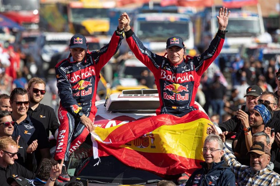 El piloto español Carlos Sainz (d) y su copiloto Lucas Cruz celebran tras proclamarse campeones del Dakar 2020.
