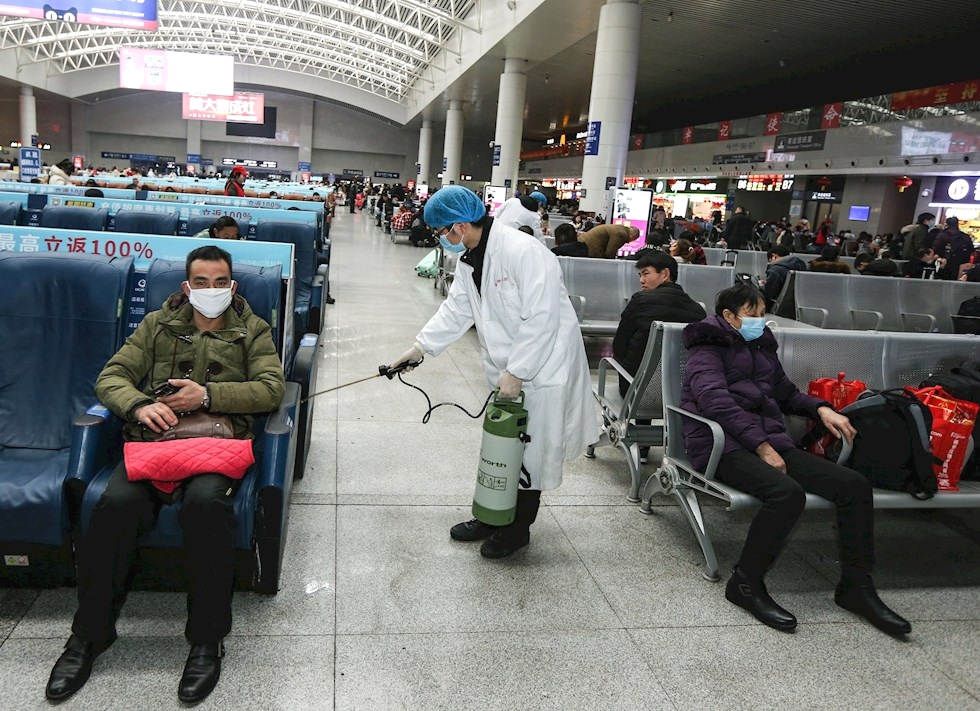 Un operario desinfecta una zona de espera para pasajeros en la estación de tren de Nanchang, en la provincia china de Jiangxi.