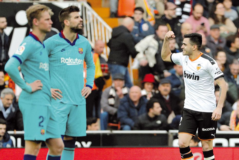 El delantero uruguayo Maximiliano Gómez (d) celebra un gol ante la desazón de los jugadores del Barcelona.