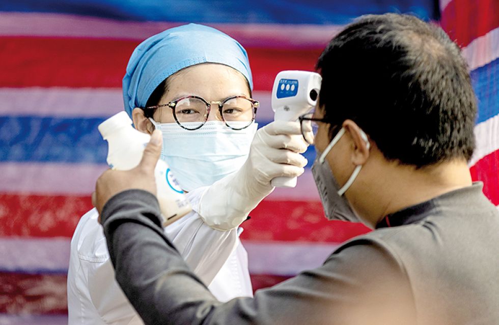 CONTROL. Un miembro del personal médico chino comprueba la temperatura corporal de un ciudadano en Guangzhou (China).