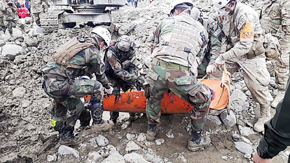 EMERGENCIA. Efectivos del Ejército rescatan el cuerpo de una de las víctimas del alud.