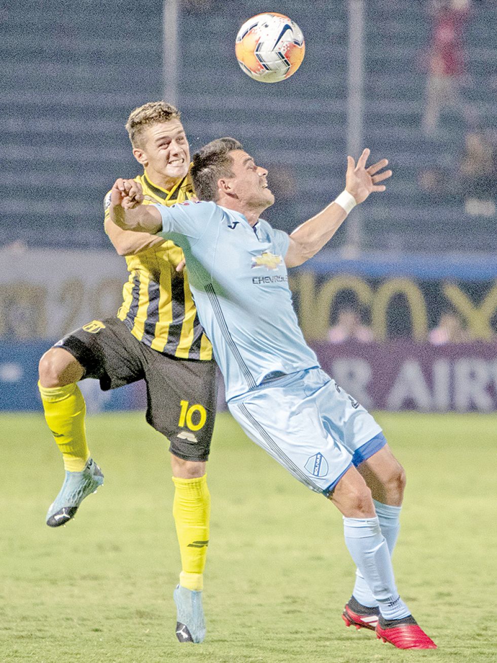 El atacante celeste Leonardo Vaca (d) intenta proteger el balón ante la marca de Bautista Merlini.