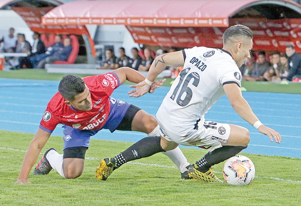 El defensor aviador Juan Pablo Aponte pelea el balón con el chileno Oscar Opazo anoche, en el partido jugado en el Félix Capriles.