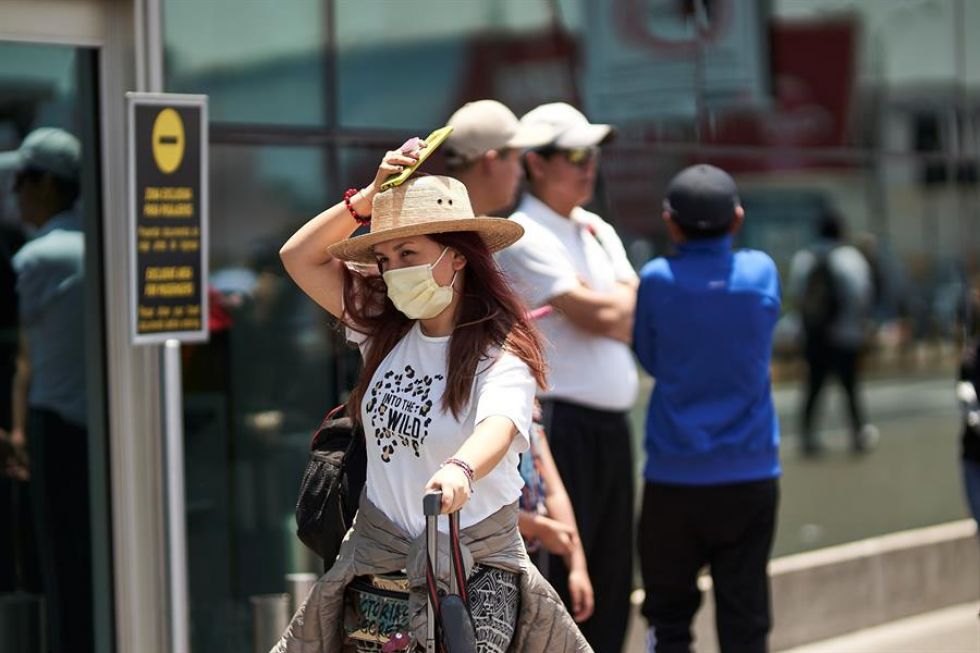 Una pasajera utiliza tapabocas como medida de protección a las afueras de uno de los terminales del Aeropuerto Internacional Jorge Chavéz ayer, en Lima.