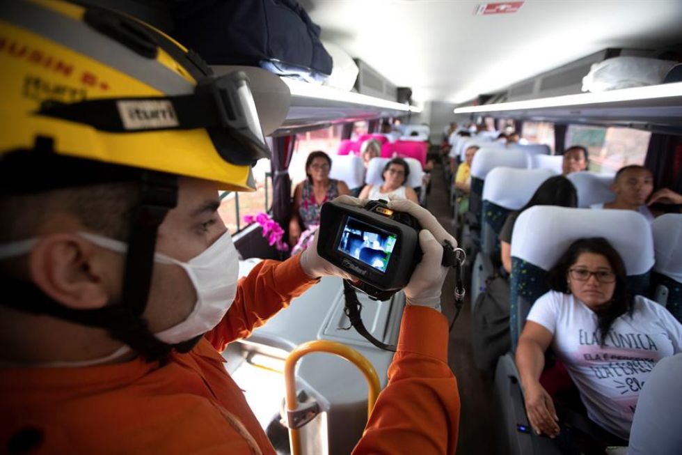 Bomberos usan cámaras térmicas y termómetros digitales para revisar los autobuses que llegan desde Sao Paulo este jueves a Brasilia.