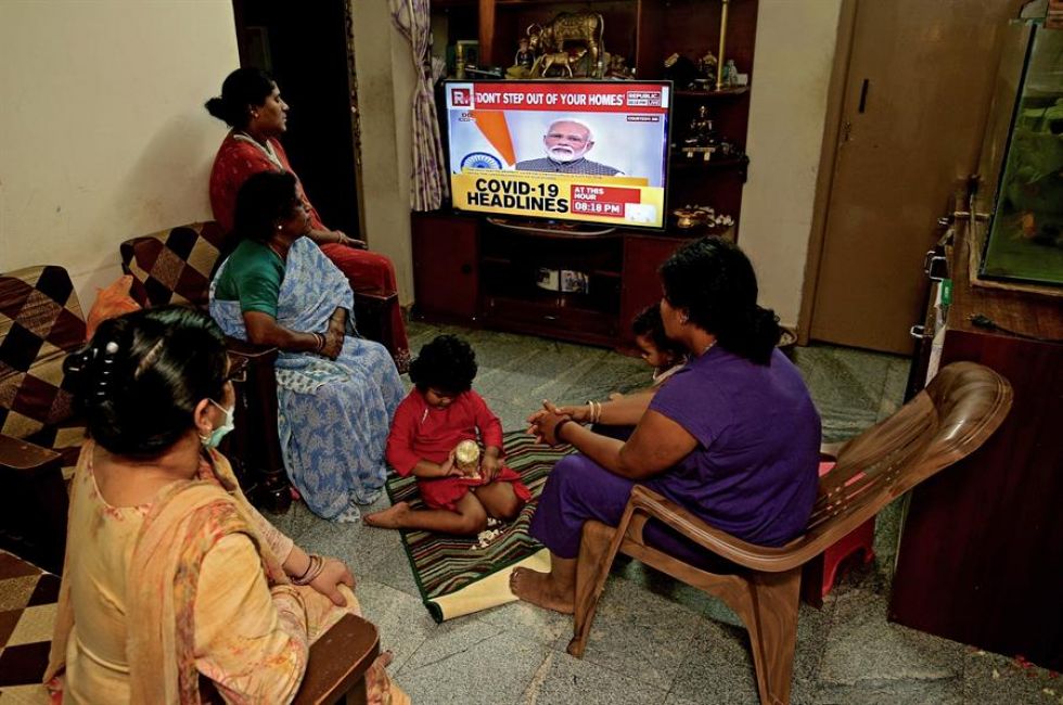 Una familia india escucha en la televisión el discurso del primer ministro Narendra Modi sobre las medidas contra el coronavirus.