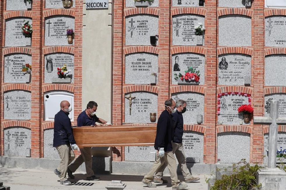 Operarios proceden al entierro de un fallecido en el cementerio de la Almudena en Madrid.