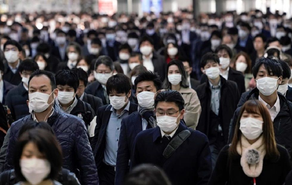 Trabajadores protegidos con mascarillas acuden a sus oficinas en Tokio, Japón, este lunes.