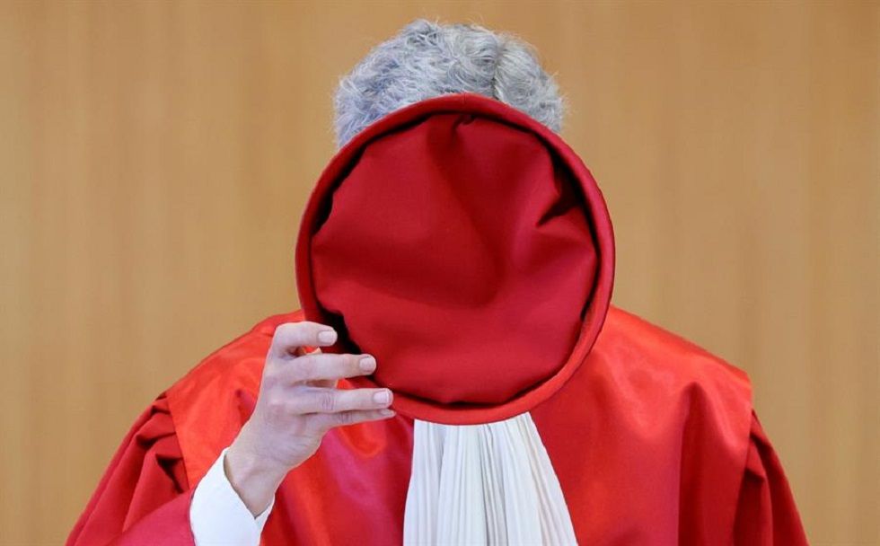 El presidente del Tribunal Constitucional, el juez Stephan Harbarth, se quita el gorro de juez antes de dictaminar sentencia.
