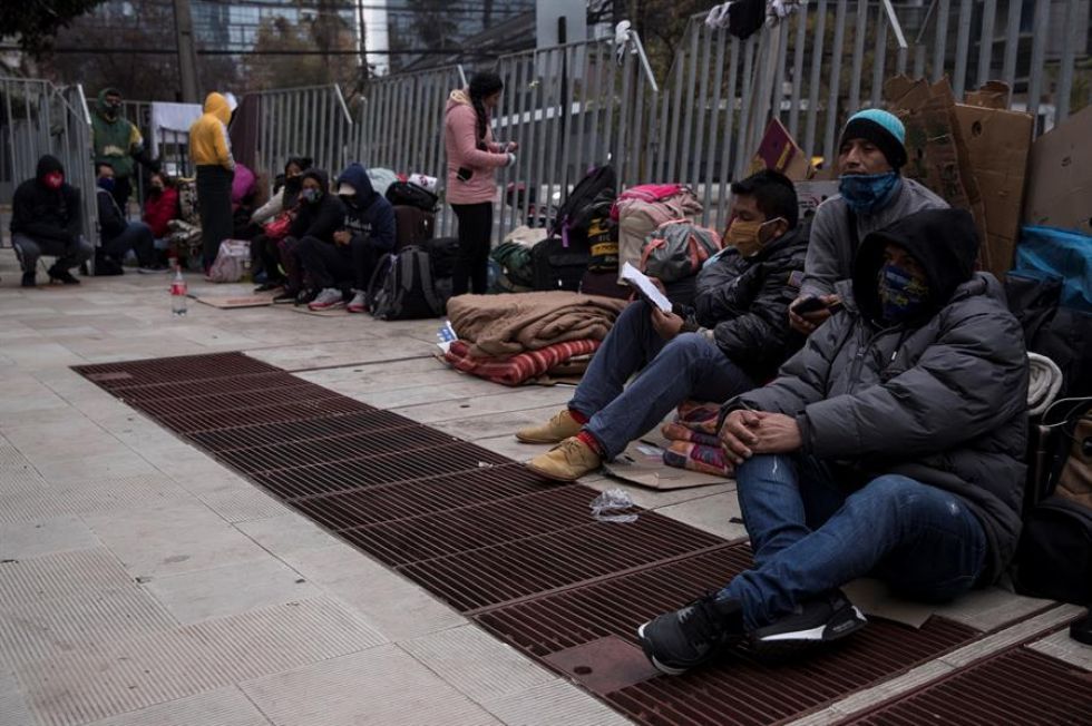 Ciudadanos peruanos acampan frente al Consulado de Perú en Santiago, a la espera de volver a su país.