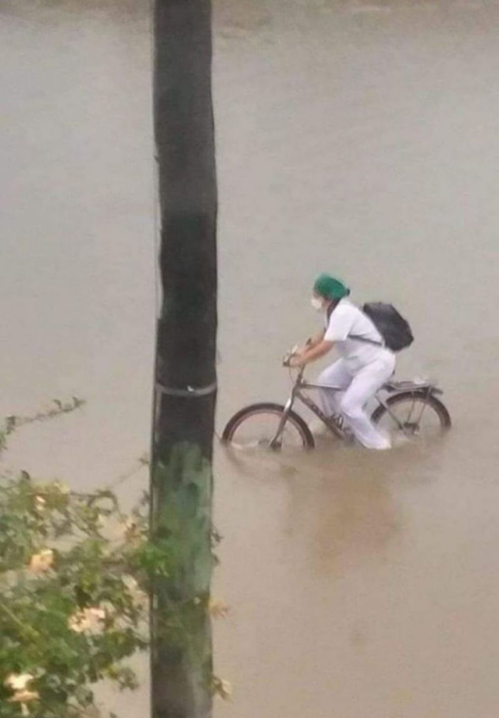 Un vecino capturó el regreso a casa de la joven en bicicleta, en medio de calles inundadas por la torrencial lluvia en Santa Cruz.