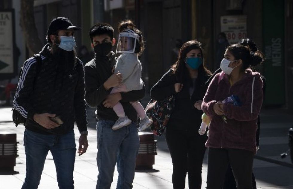 Personas con máscaras faciales caminan por la Plaza de Armas en Santiago, en medio de la nueva pandemia de coronavirus.