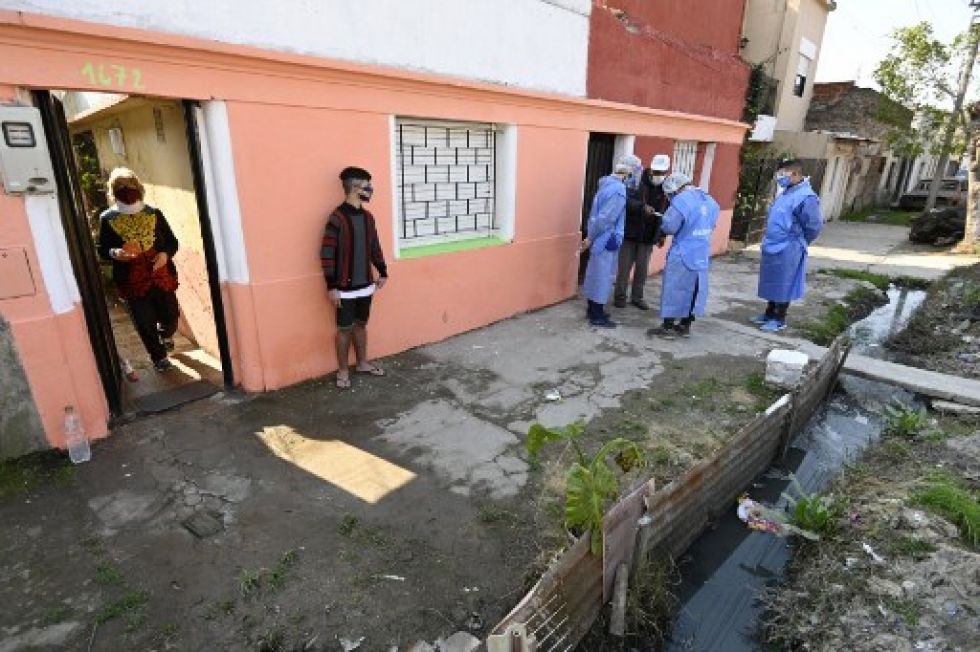 Voluntarios de salud hablan con los lugareños durante una visita para detectar personas con síntomas de covid-19 en Villa Fiorito, afueras de Buenos Aires.