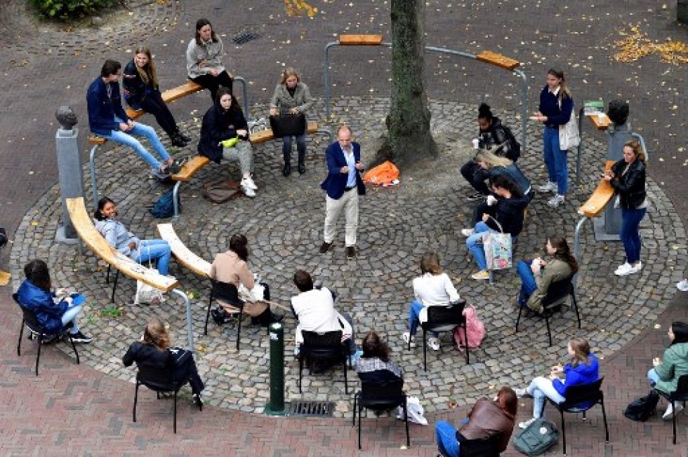El profesor holandés Edward Nieuwenhuis de la Universidad Roosevelt College da clases a 25 estudiantes afuera, en una plaza.
