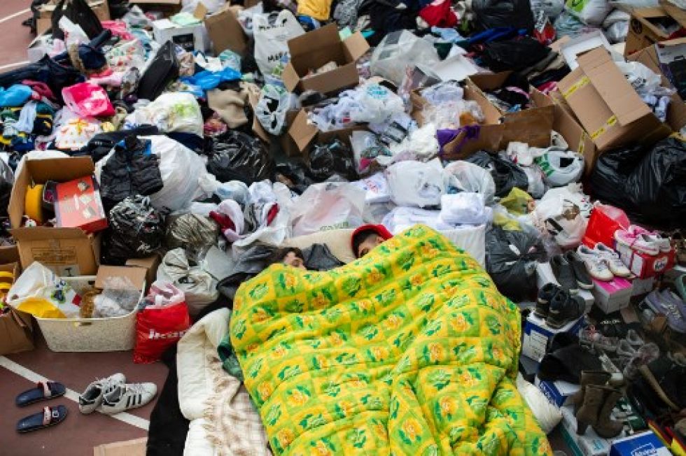 La gente duerme junto a los suministros humanitarios en el distrito de Bayrakli en Izmir, después de que un terremoto sacudiera Turquía y Grecia.