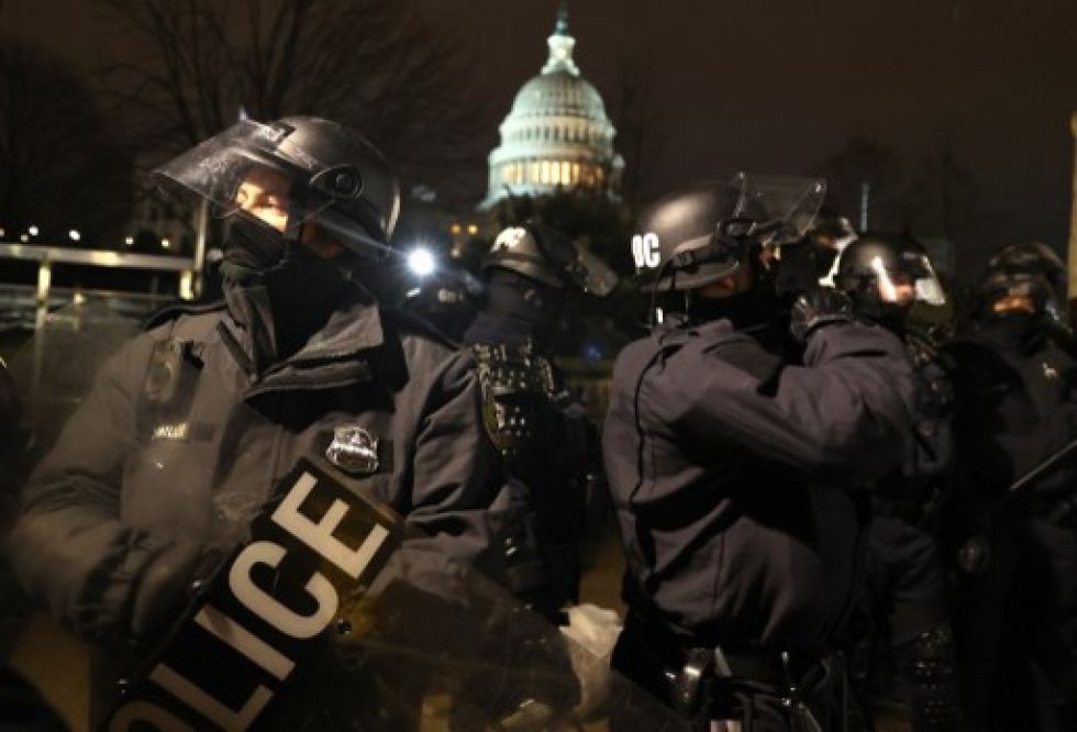 Oficiales de policía con equipo antidisturbios trabajan para dispersar a los manifestantes que se están reuniendo en el Capitolio.