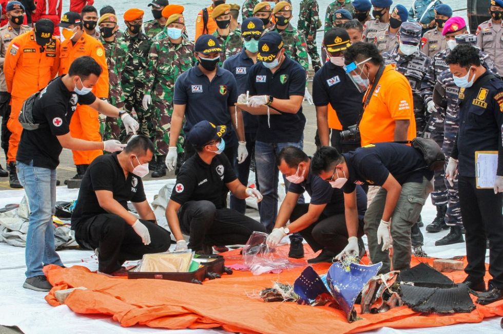 Los equipos de rescate inspeccionan las piezas halladas del avión que se estrelló el sábado.