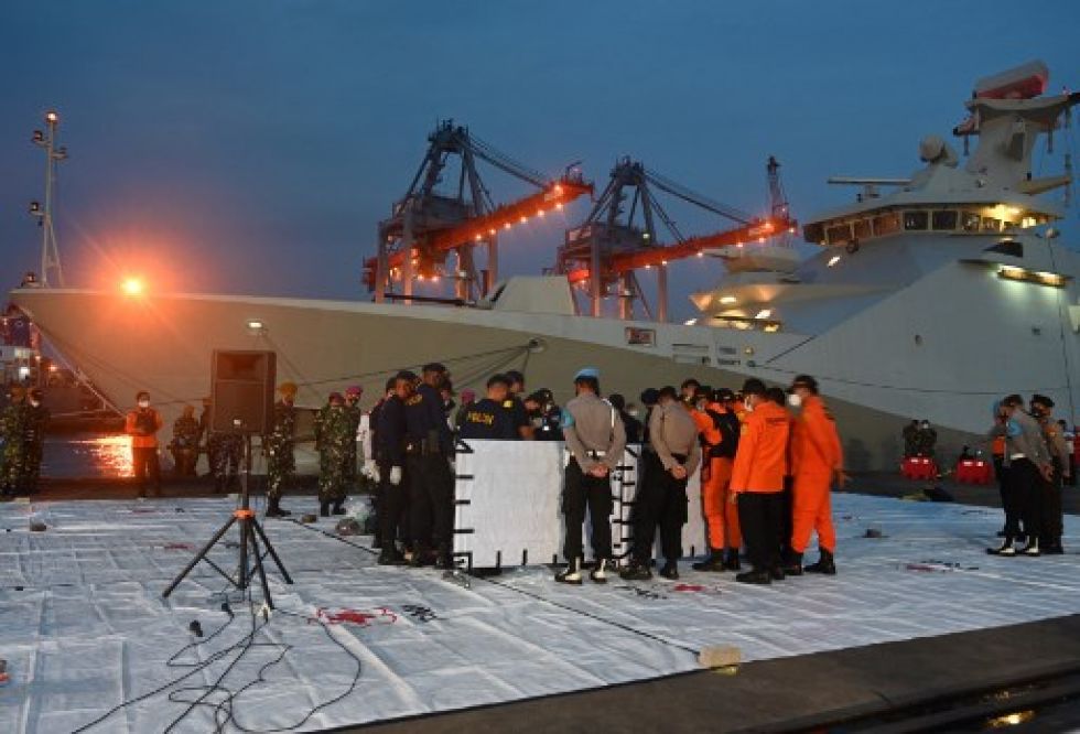 La policía forense de Indonesia examina las partes del cuerpo de los pasajeros del vuelo SJ182 de Sriwijaya Air en el puerto de Tanjung Priok.