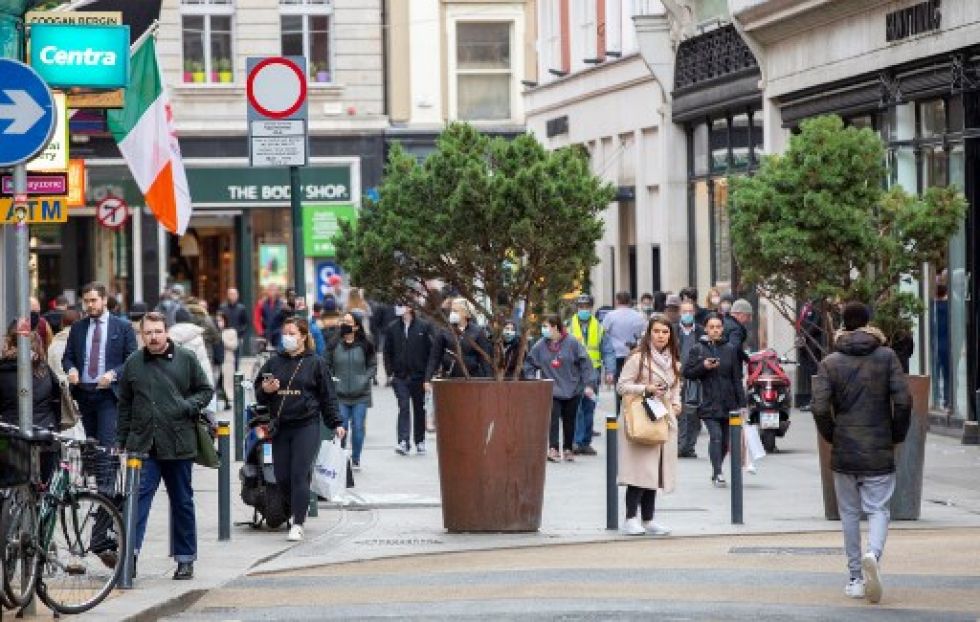 Algunas personas llevan mascarillas mientras caminan en una calle comercial de Dublín.