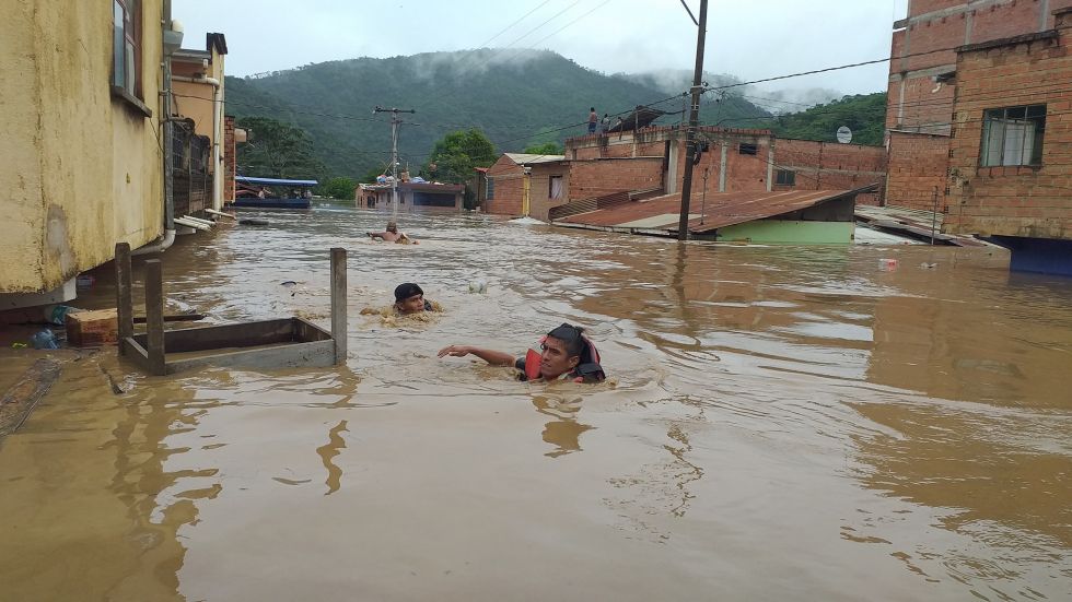 Un hombre nada en una calle de Guanay, que quedó inundada por el desborde de dos ríos.