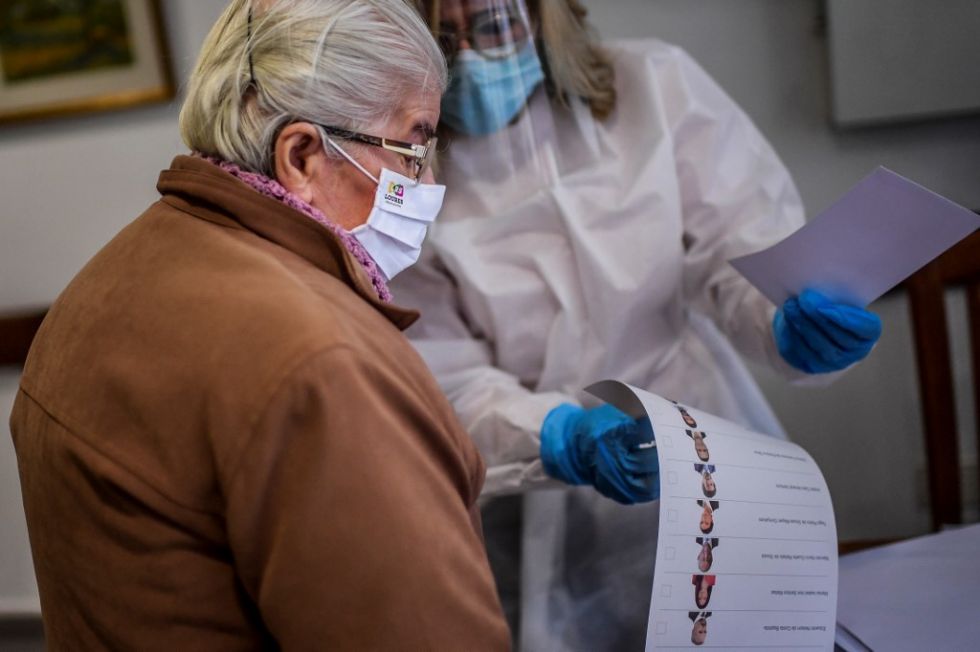 Un residente de un hogar de ancianos recibe documentos para emitir un voto anticipado para las elecciones presidenciales.