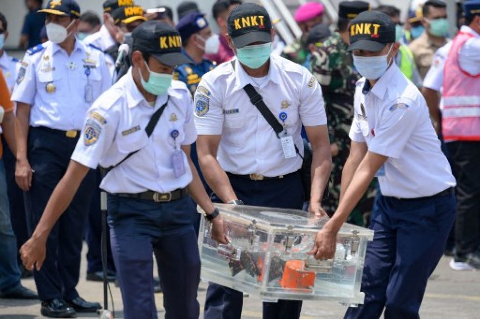 Los funcionarios indonesios llevan la caja que contiene una grabadora de voz en la cabina, recuperada durante las operaciones de búsqueda del avión Sriwijaya Air Boeing 737-500.