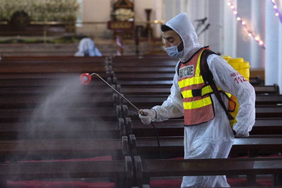 Un trabajador desinfecta la catedral de San Juan de Pakistán como medida preventiva contra el covid-19.