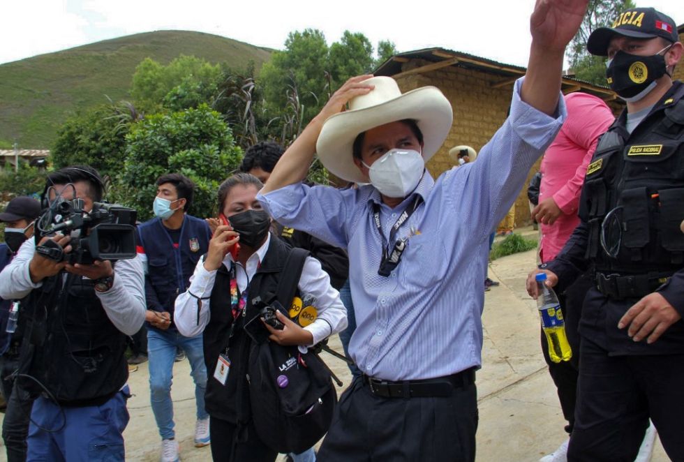 El candidato presidencial por el Partido Perú Libre, Pedro Castillo, saluda al salir de un colegio electoral.