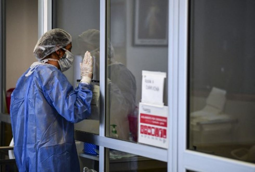 Una mujer reza mientras visita a un familiar infectado con covid-19 en la Unidad de Cuidados Intensivos del hospital El Cruce - Dr. Nestor Kirchner.