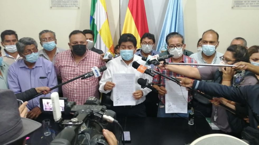 El ministro Edgar Montaño (c) muestra el acuerdo firmado con los transportistas.