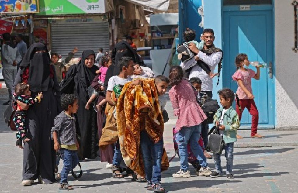 Familias palestinas cargan sus pertenencias en una calle de Rafah, luego de los intensos bombardeos de la aviación y artillería israelíes del último fin de semana.