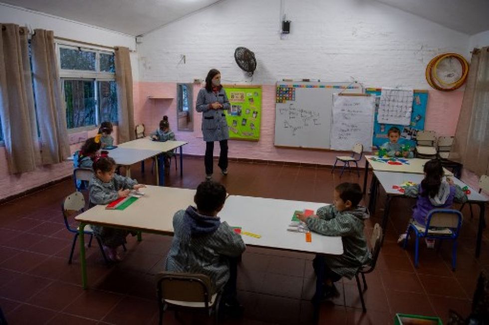 Una maestra habla con niños de preescolar durante una clase en una escuela pública de Montevideo.