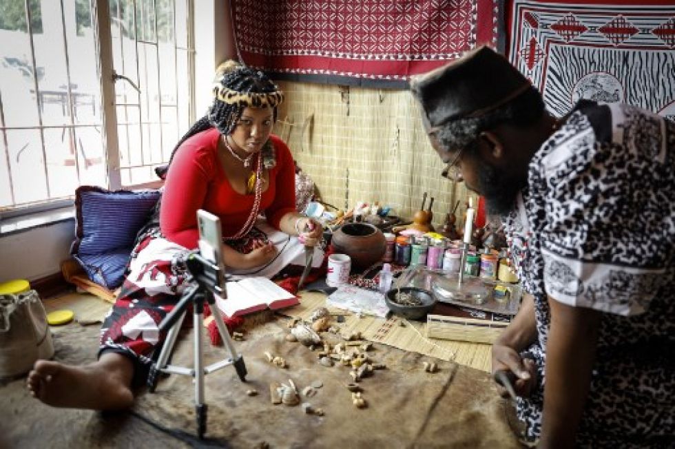 La curandera tradicional Gogo Kamo (izq.), Realiza una consulta en línea con un cliente en su sala de consulta en Kempton Park.