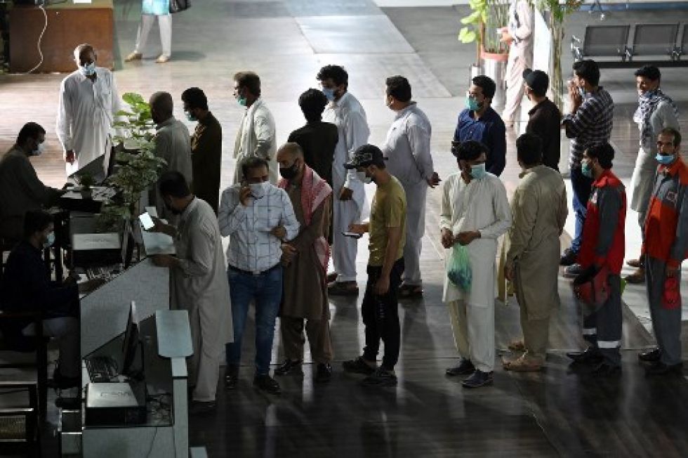 Personas hacen fila ante un centro de vacunación en Pakistán, otro de los países golpeados por la pandemia del coronavirus.