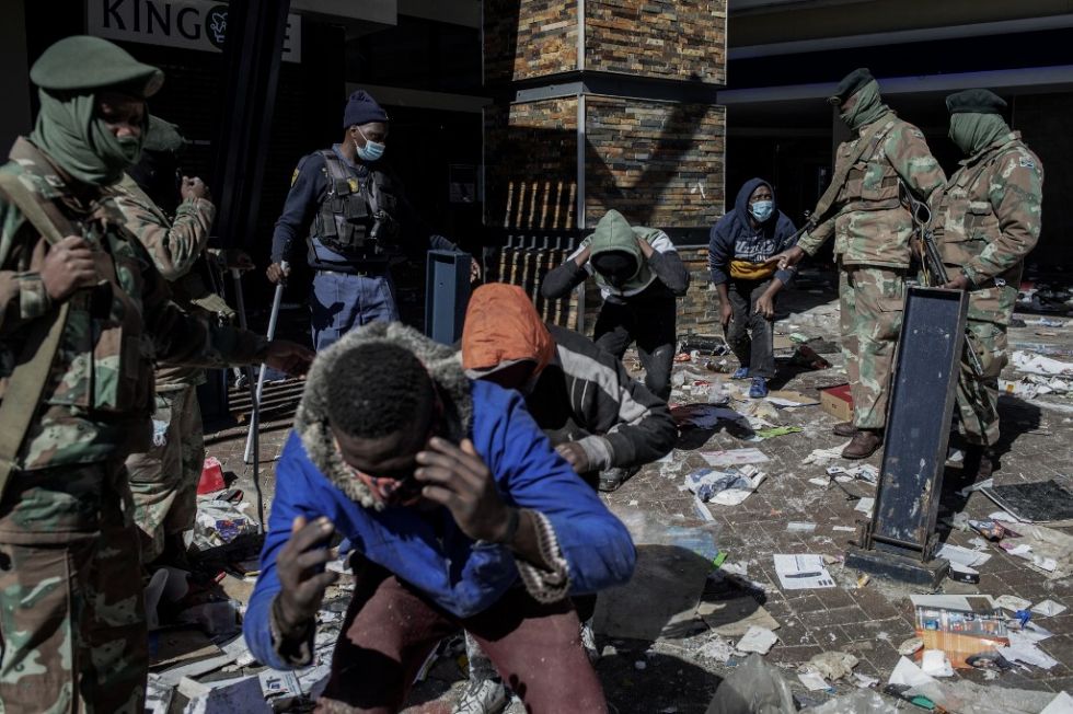 Soldados de las fuerzas de seguridad de Sudáfrica detienen a presuntos saqueadores en Jabulani Mall en Soweto.
