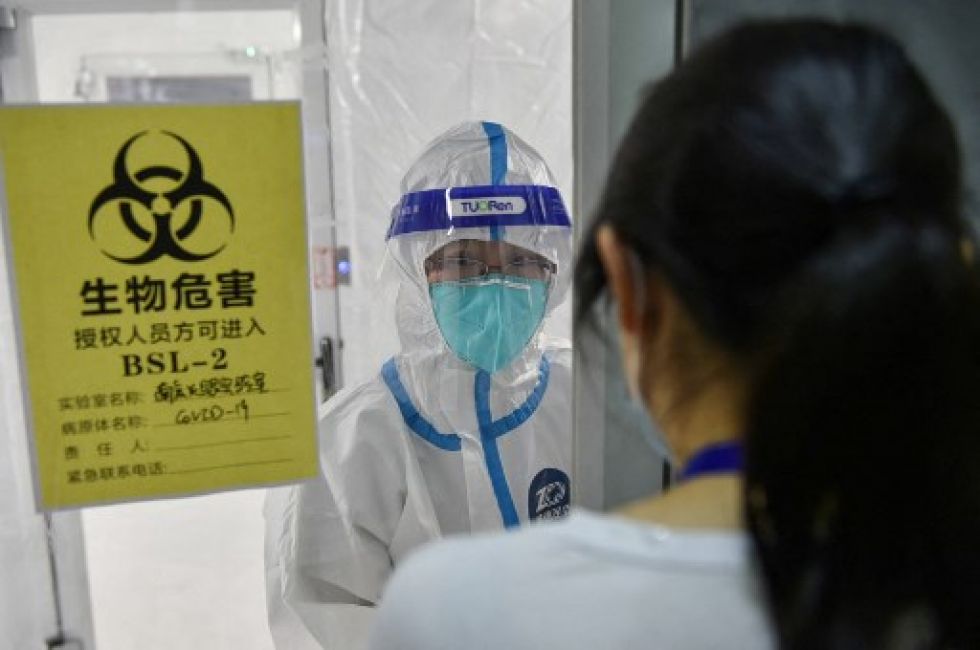 Personal médico hablando dentro de un área de aislamiento en un laboratorio temporal en el este de China.