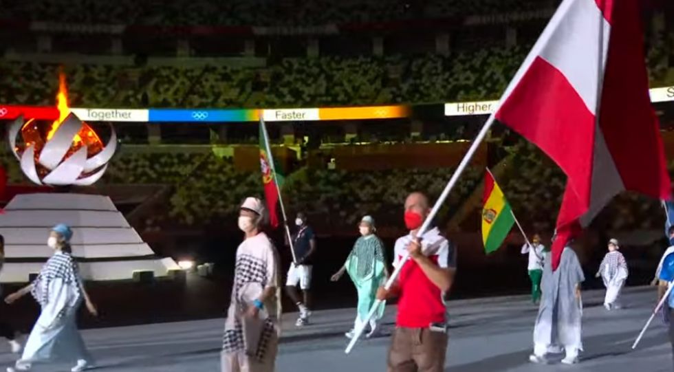 La boliviana Ángela Castro (al fondo a la derecha) lleva la bandera nacional en la ceremonia de clausura.