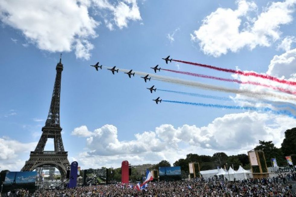 La patrulla aérea francesa 'Patrouille de France' sobrevuela la aldea de fans de El Trocadero frente a la Torre Eiffel, este domingo. STEPHANE DE SAKUTIN / AFP