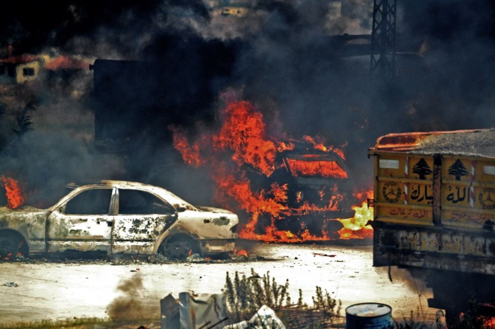 Los vehículos se queman cerca del lugar donde se colocó el tanque de combustible explotado, en Akkar.