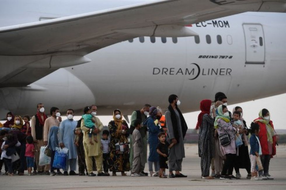 Un grupo de refugiados afganos desciende de un avión en la base aérea de Torrejón, en España, tras ser evacuados desde Kabul.