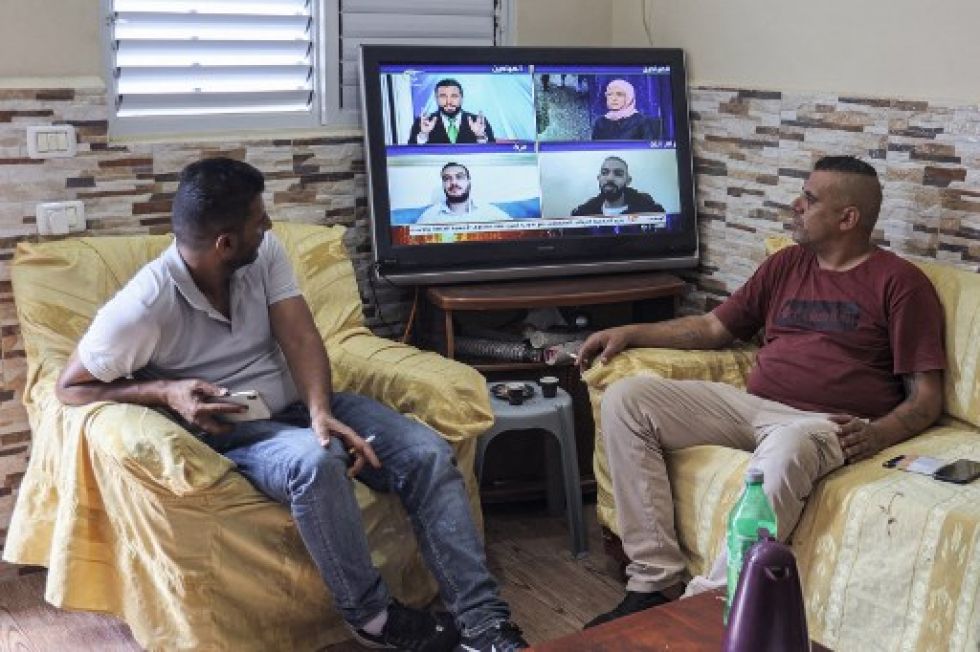 Familiares de uno de los presos fugados siguen las noticias mediante la televisión en su casa de la Franja de Gaza.