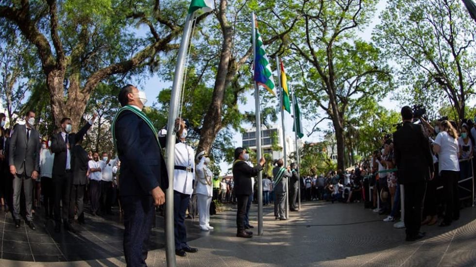 La iza de las banderas durante el acto oficial por la efeméride de Santa Cruz.